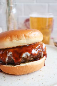 a meatball sandwich on a bun covered in bbq sauce