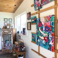 a living room filled with lots of paintings on the wall