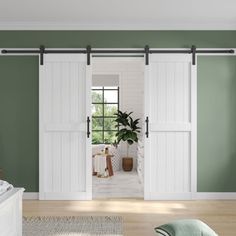 a living room with green walls and white sliding doors