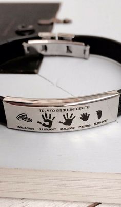 a black leather bracelet with hand prints on it