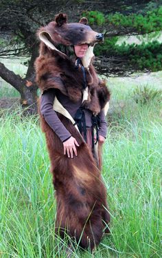 a person in a bear costume standing in the grass