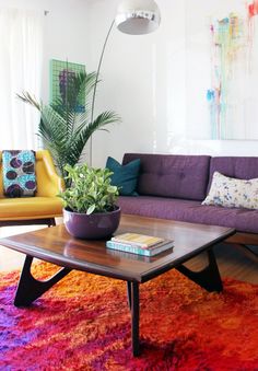 a living room filled with furniture and a potted plant on top of a coffee table