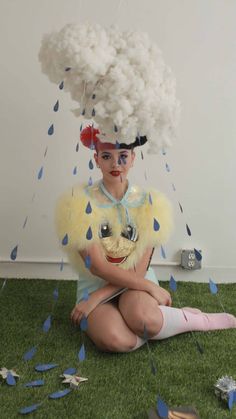 a woman is sitting on the ground with her hair blowing in the wind and holding a stuffed animal