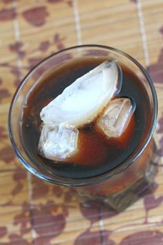 jack and coke cocktail recipe in a glass with ice cubes