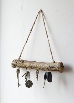 several keys hanging from a wooden branch on a wall