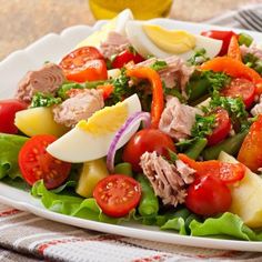 a white plate topped with salad and meat