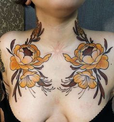 a woman with tattoos on her chest has flowers painted on her chest and is looking at the camera