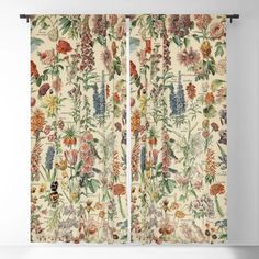 an open window curtain with flowers and plants printed on the outside, in front of a white wall