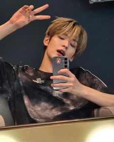 a person taking a selfie in front of a mirror with their hand up to the camera