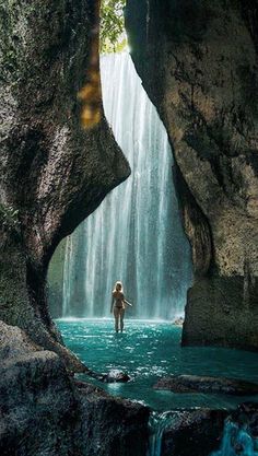 a person standing in the middle of a waterfall