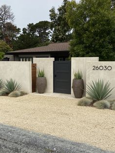 a house with two large planters in front of it and the number 20 on the wall