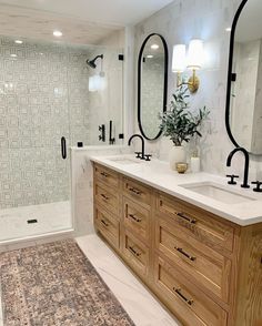 a bathroom with two sinks, mirrors and a rug on the floor in front of it