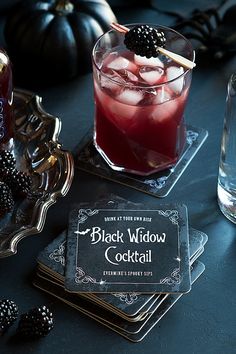 a black widow cocktail on coasters next to a bottle of booze