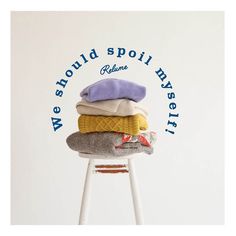 a stack of sweaters sitting on top of a stool with the words we should hold spoil