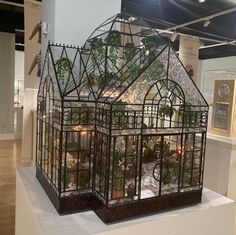 a glass house with plants inside on display