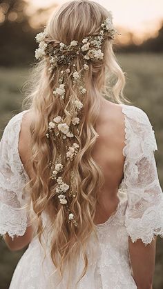 a woman with long blonde hair and flowers in her hair, wearing a white dress