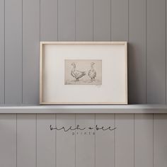 two ducks sitting on top of a shelf next to a framed print with the word break in bed written below