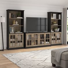 an entertainment center with bookshelves, television and couch in a living room setting