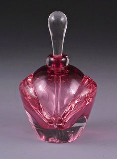 a pink glass bottle sitting on top of a table