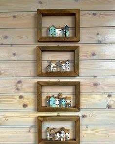 three wooden frames with small houses on them