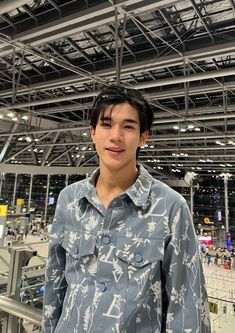 a young man standing in front of a metal structure