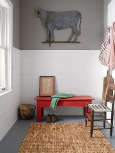 a room with a red bench and cow artwork on the wall