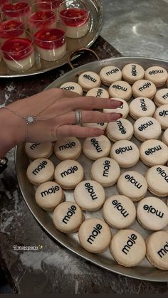 a woman's hand on top of some cookies with words that spell out the word mom