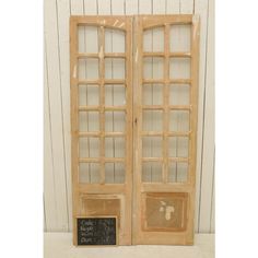 an open wooden door with a chalkboard attached to it