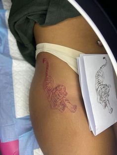 a woman's stomach with a tiger tattoo on it, next to a book