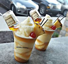 two ice cream sundaes with hot dogs in them sitting on top of a table