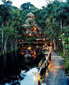 a boat is docked at the end of a wooden dock in front of a house