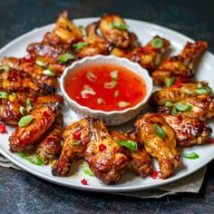 chicken wings with dipping sauce on a white plate