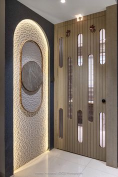 the entrance to a modern home with an oval mirror on the wall and arched glass doors