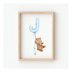 a bear holding a blue balloon with the letter j hanging from it's side