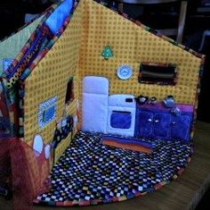 a doll house made out of quilts on a table