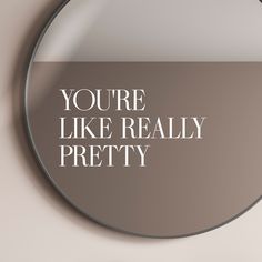 a round mirror with the words you're like really pretty in white on it