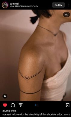 the back of a woman's shoulder with an arrow tattoo on her left arm