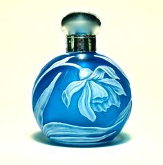 a blue glass bottle with a white flower on it