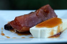 two pieces of food sitting on top of a white plate covered in sauce and cheese