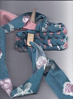 a blue scarf with pink flowers on it and a wooden hanger in the middle