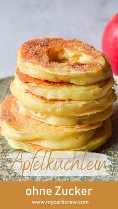 a stack of pancakes with apples in the background