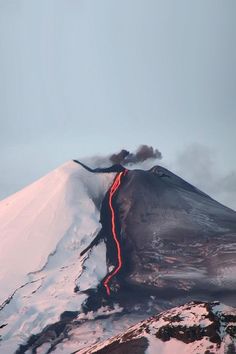 a very tall mountain with a red line going up it's side in the snow