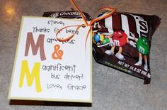 a candy bar with a note attached to it sitting next to a bag of m & m