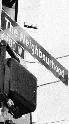 black and white photograph of street signs on the corner of neighlbourhood