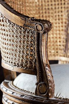 an ornate wooden chair sitting on top of a cushion