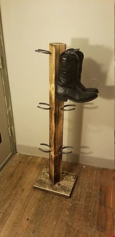 a pair of black boots are sitting on top of a shoe rack in a room