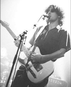 a man playing an electric guitar while singing into a microphone