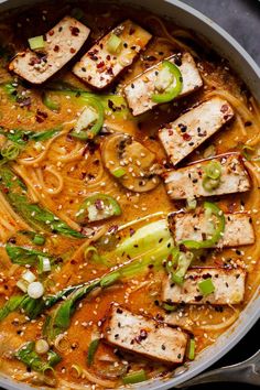 a pan filled with noodles, chicken and vegetables