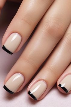 a woman's nails with black and white nail polishes on top of them