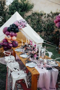 a table set up for a party with balloons